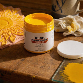 Encre de sérigraphie Tri-Art Yellow Deep dans un pot ouvert avec échantillon de tissu