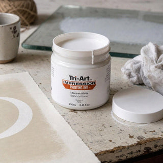 Encre de bloc Tri-Art blanc titane en pot ouvert avec échantillon d'impression arc blanc