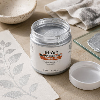 Encre de bloc Tri-Art argentée iridescente en pot ouvert avec échantillon d'impression à feuille métallique